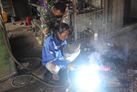 Anggota Satgas TMMD Luangkan Waktu Untuk Belajar Mengelas Bersama Bapak Kristian