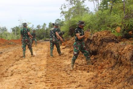 Personel Satgas TMMD Lakukan Gotong Royong Ratakan Badan Jalan